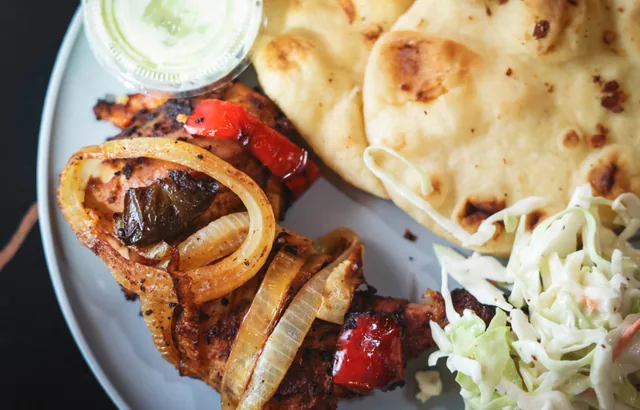 Tandoori chicken with charred onions and peppers, served with naan, coleslaw and a creamy dip